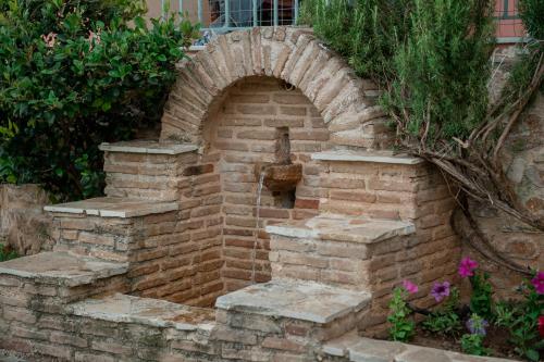 a brick oven with a water fountain in a garden at Helios Residence in Spáta