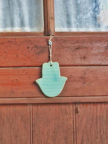a wooden door with a green tag hanging on it at בקתת מטיילים in Mitzpe Hila