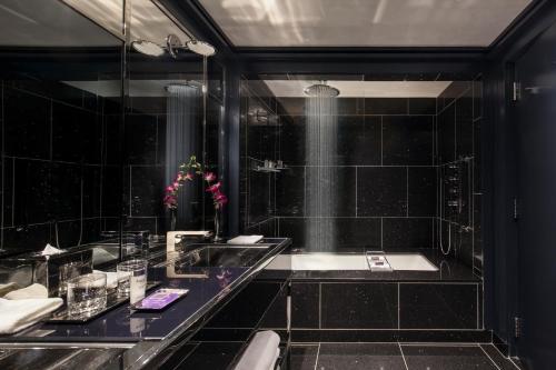 
a person standing in a bathroom in front of a sink at The Chatwal, a Luxury Collection Hotel, New York City in New York

