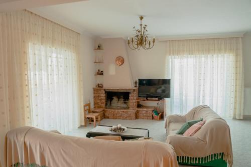 a living room with two couches and a fireplace at Helios Residence in Spáta