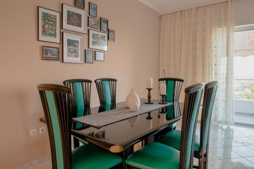 a dining room with a table with green chairs at Helios Residence in Spáta