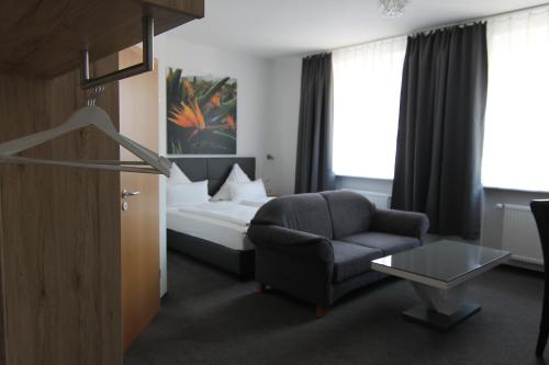 a hotel room with a bed and a chair at Hotel & Restaurant Blume in Wolfsburg