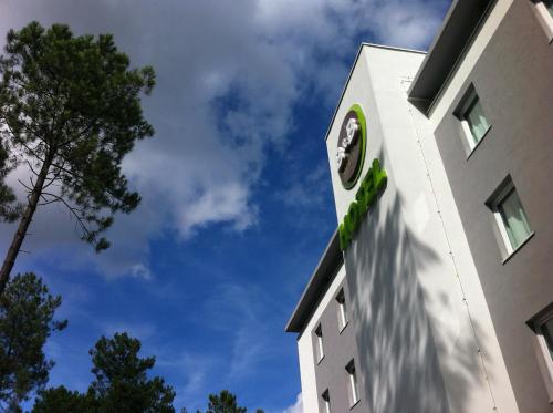 a building with a clock on the side of it at B&B HOTEL Mont-de-Marsan in Saint-Avit