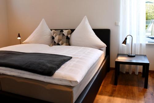 ein Bett mit einer schwarzen und weißen Bettdecke und einem Tisch in der Unterkunft Zum Anker in Simmerath