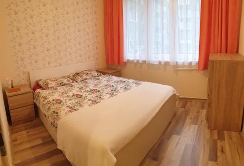 - une chambre avec un lit fleuri dans l'établissement Orhidea Apartman, à Gheorgheni