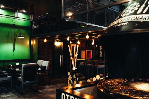 a restaurant with a grill with a table and chairs at Aleanda in Chernivtsi