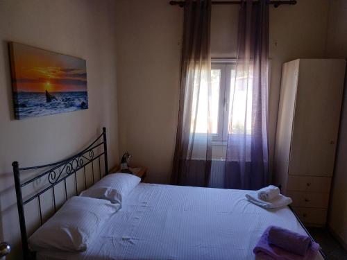 - une chambre avec un lit et une fenêtre dans l'établissement Near AirportAnd metropolitan Penelopi Cozy Home, à Artemi