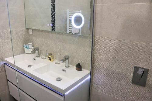 une salle de bain avec un lavabo et une douche avec un miroir dans l'établissement 2P NEUF vue Promenade des Anglais / Tram 10min centre, à Nice