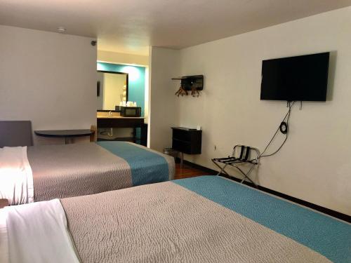 a hotel room with two beds and a flat screen tv at Motel 6-Nashville, TN - Airport in Nashville