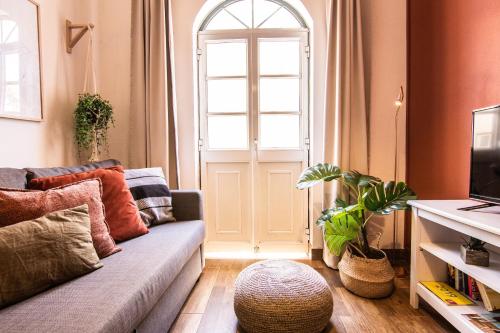 a living room with a couch and a window at Faro Central - Holiday Apartments in Faro