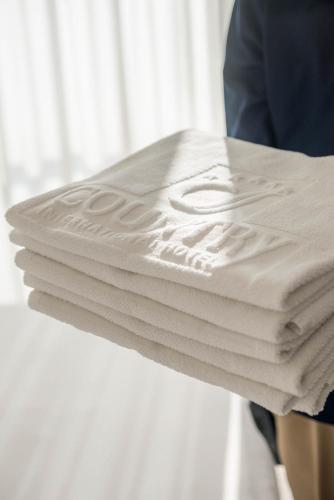 a stack of white towels sitting on a table at Country International Hotel in Barranquilla