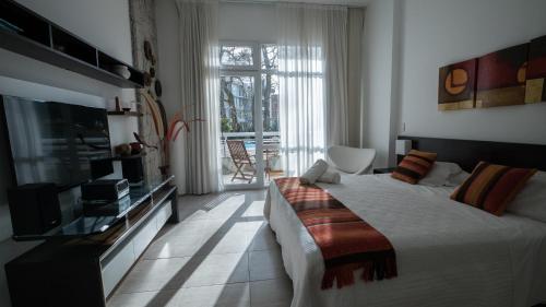 a bedroom with a large bed and a television at Sea Point By D&G in Carilo