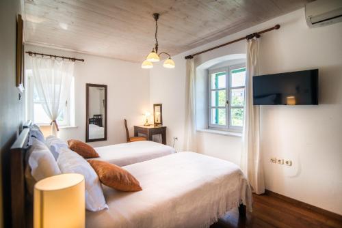 Un dormitorio con dos camas y un televisor en la pared. en Villa Maruka, en Supetar