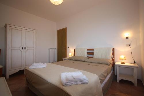 - une chambre avec un lit et des serviettes dans l'établissement Terrazza su Fosso Bianco, à Bagni San Filippo