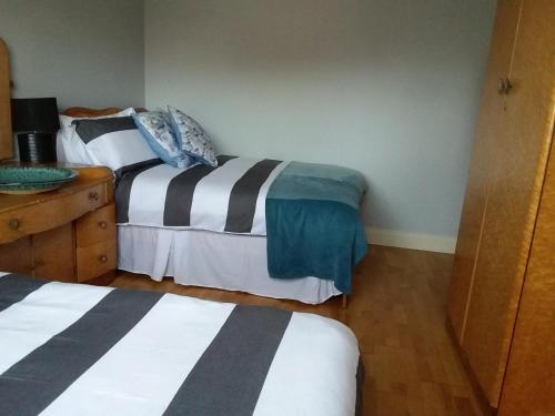 a bedroom with two beds and a wooden dresser at Carriglea in Listowel