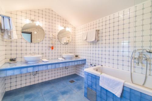 a blue and white bathroom with two sinks and a tub at Villa Maruka in Supetar