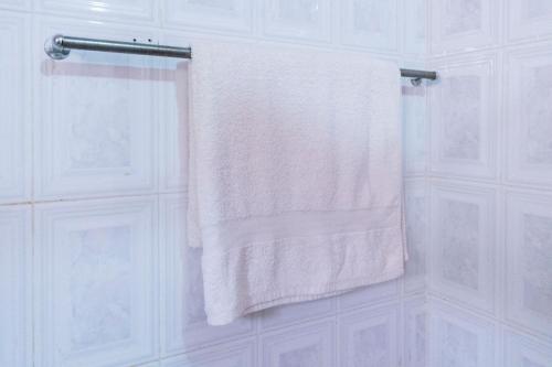 toalla blanca colgada en un toallero en el baño en Starlight Hotel Mbale, en Mbale