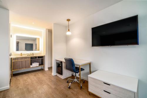 a hotel room with a desk and a tv on the wall at Trend Hotel at LAX Airport in Inglewood