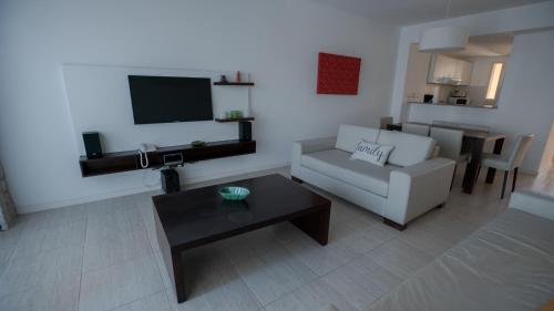 a living room with a couch and a table at Sea Point By D&G in Carilo