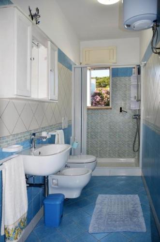 a blue and white bathroom with two toilets and a sink at Casa vacanze spiaggia dorata in Marina di Pescoluse
