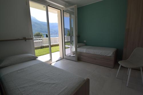 um quarto com uma cama e uma porta de vidro deslizante em Appartamento Fiordaliso Bellagio Wild Flowers - HOT TUB em Onno