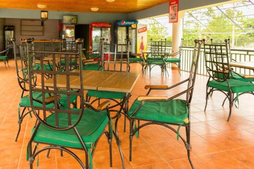a group of green chairs and tables in a restaurant at Soroti Hotel 2001 in Soroti
