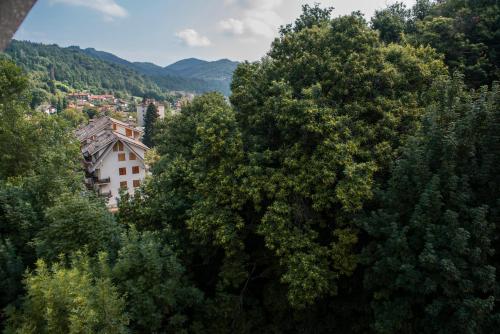 a view of a building through the trees at Mansardato In Lurisia in Lurisia