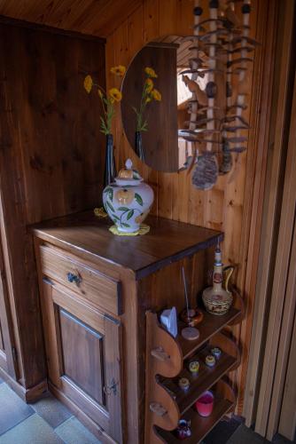 a wooden cabinet with a vase on top of it at Mansardato In Lurisia in Lurisia