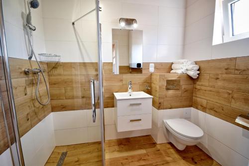 a bathroom with a toilet and a glass shower at Piasek i Woda Domki in Grzybowo