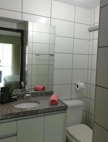 a bathroom with a sink and a toilet and a mirror at Beach Class Rosalux 707 in Fortaleza