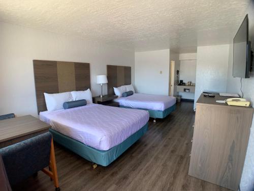 a hotel room with two beds and a television at Brookings Inn Resort in Brookings