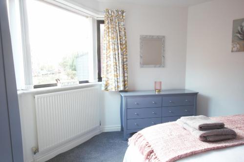 a bedroom with a bed with a blue dresser and a window at Canal House in Chester