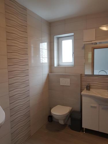 a bathroom with a toilet and a sink at Garden Apartments Maria in Bled