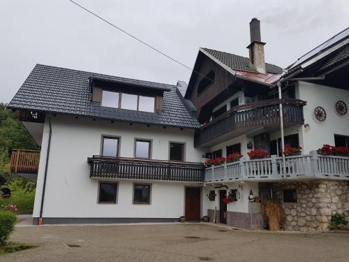 a white house with balconies on the side of it at Garden Apartments Maria in Bled