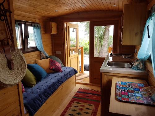 une petite chambre avec un canapé dans une petite maison dans l'établissement La Roulotte du Haut Pinleu, à Pernes-lès-Boulogne