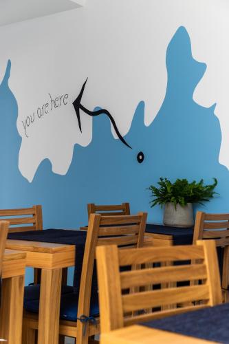 a dining room with a table and chairs and a blue wall at AZUL in Zambujeira do Mar