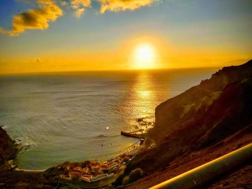 a sunset over the ocean with a group of boats at Vv - Casa Clary -Finca Medina in Alojera