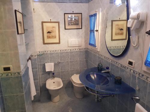 a bathroom with a sink and a toilet and a mirror at Villa il Lauro in Pisa