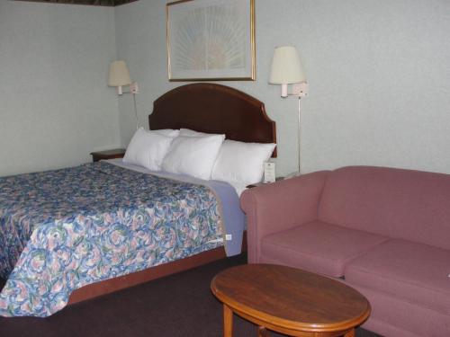 a hotel room with a bed and a couch at Budget Inn in Alcoa