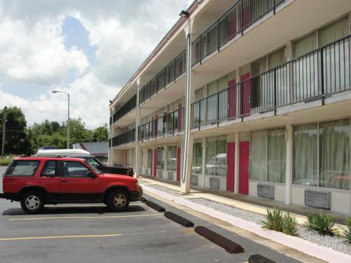 un coche rojo estacionado frente a un edificio en Budget Inn en Alcoa