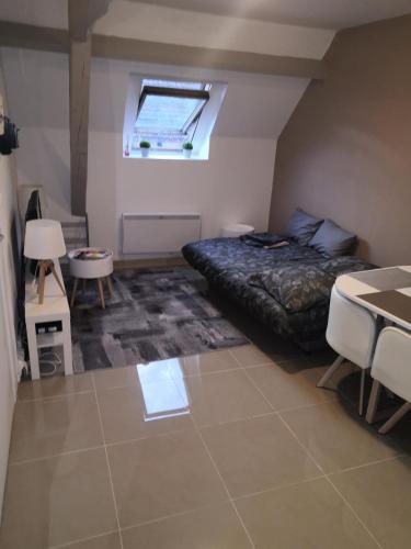 a bedroom with a bed and a table and a window at Cosy village in Bonneuil-en-France