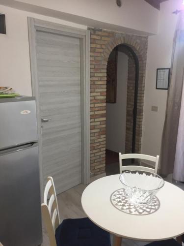 a kitchen with a white table and a refrigerator at ToviMar Apartments in Taormina