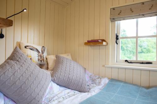 a bedroom with a bed with a pillow and a window at Romantic secluded Shepherd Hut Hares Rest in Southwick