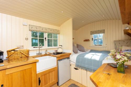 Southwick的住宿－Romantic secluded Shepherd Hut Hares Rest，一个带水槽的厨房和一张位于客房内的床