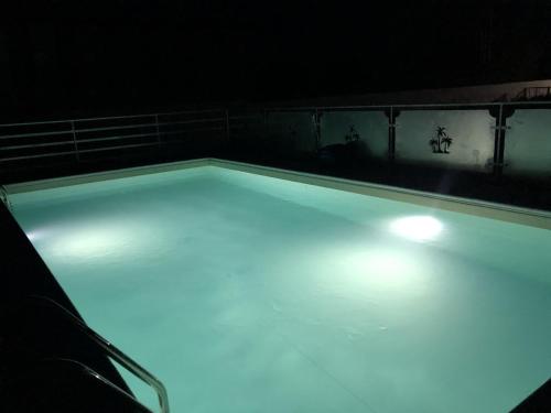 a swimming pool with blue lights in a dark room at Veda elegant rooms in Fiumefreddo di Sicilia