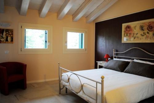 um quarto com uma cama e duas janelas em Bed And Breakfast Castello em Villafranca di Verona