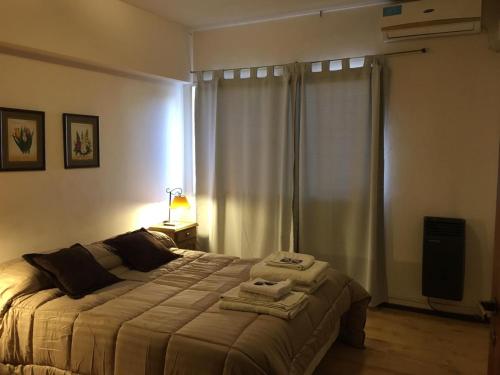1 dormitorio con 1 cama con 2 toallas en Mendoza pleno centro en Mendoza