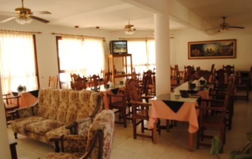 a living room with couches and tables and chairs at Hotel Tykua in Gualeguaychú