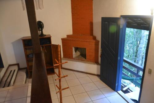 a living room with a fireplace and a door at Pousada Moinho Azul in Teresópolis