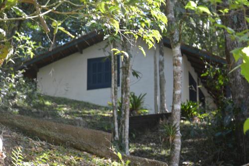 a white house in the middle of some trees at Pousada Moinho Azul in Teresópolis